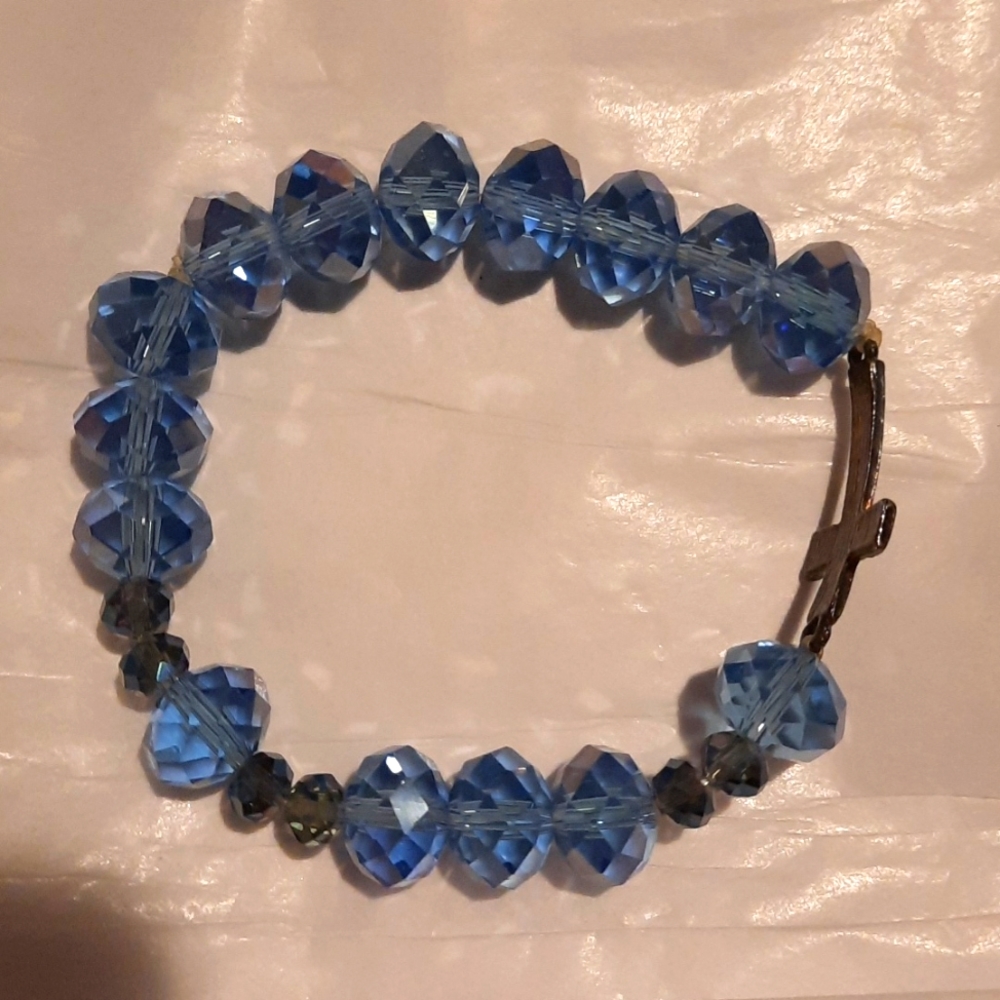 Blue crystal stretch bracelet with copper colored cross